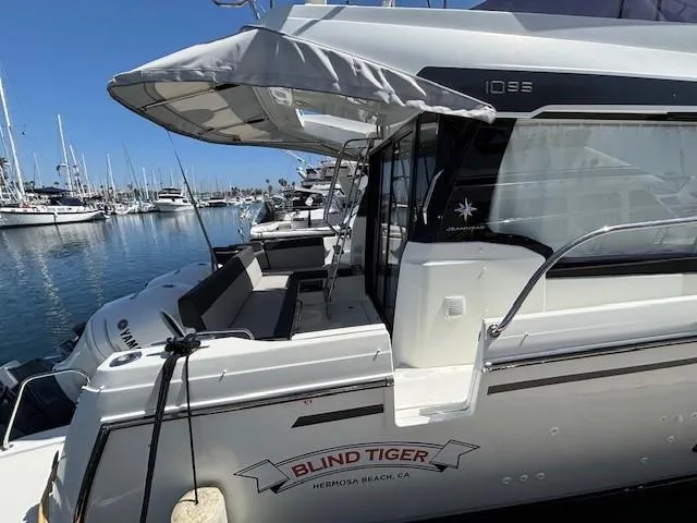 Slide: The Image of 2020 Jeanneau NC 1095 Fly yacht docked at marina, featuring sleek design and canopy. - 30