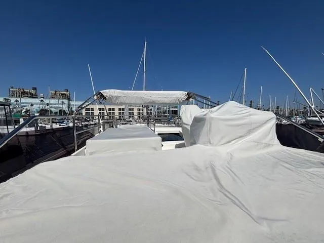 Slide: The Image of 2020 Jeanneau NC 1095 Fly yacht with covered deck, docked at marina under clear blue sky. - 35