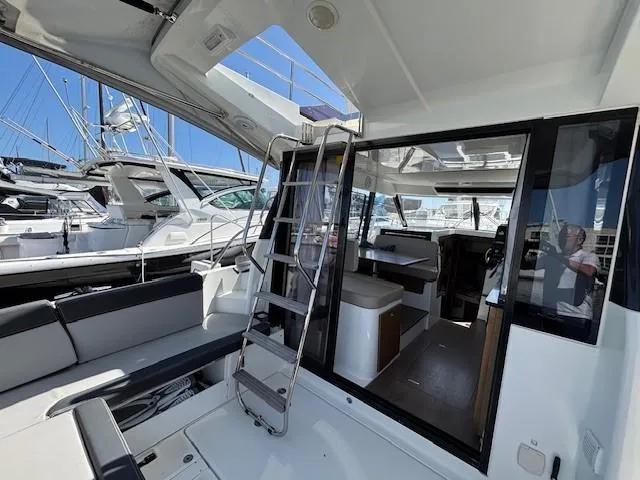 Slide: The Image of 2020 Jeanneau NC 1095 Fly yacht interior with seating and ladder, docked at marina. - 49