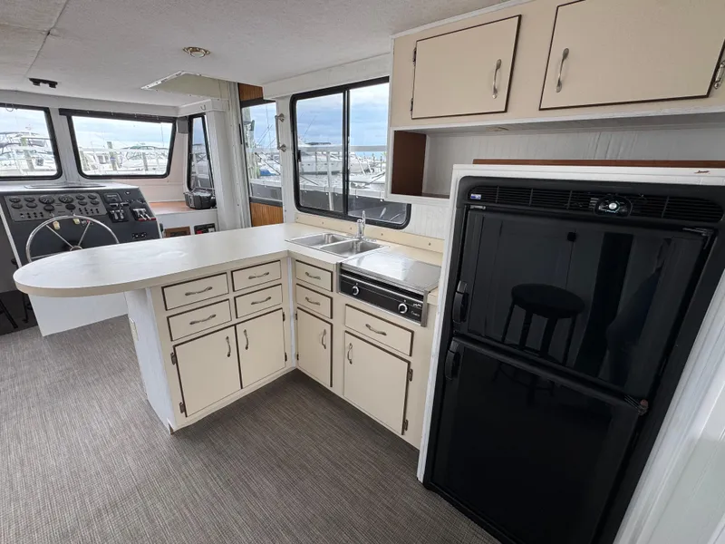 Slide: The Image of Interior of 1993 Gibson 37 Sport Series boat with kitchen and helm area. - 12