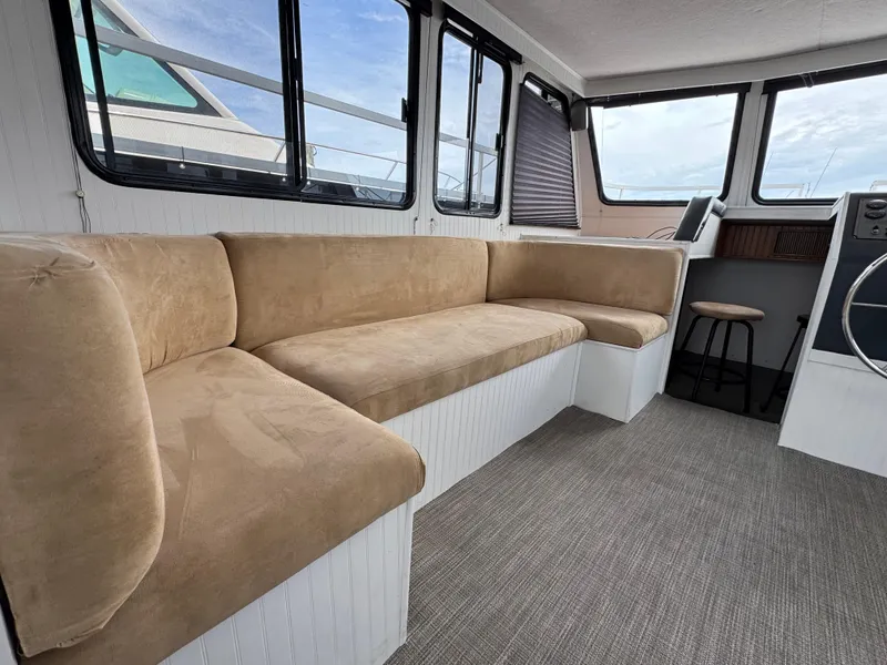 Slide: The Image of Interior of 1993 Gibson 37 Sport Series boat with beige seating and large windows. - 13