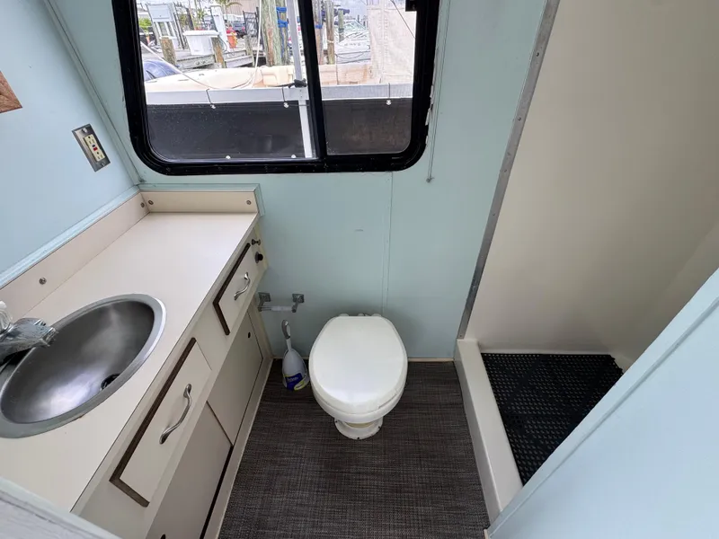 Slide: The Image of Bathroom interior of 1993 Gibson 37 Sport Series boat with sink, toilet, and shower. - 16