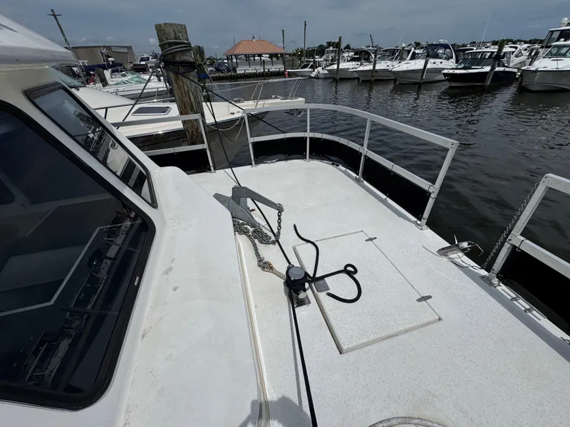 Slide: The Image of 1993 Gibson 37 Sport Series boat docked at marina, showing deck and railing. - 17