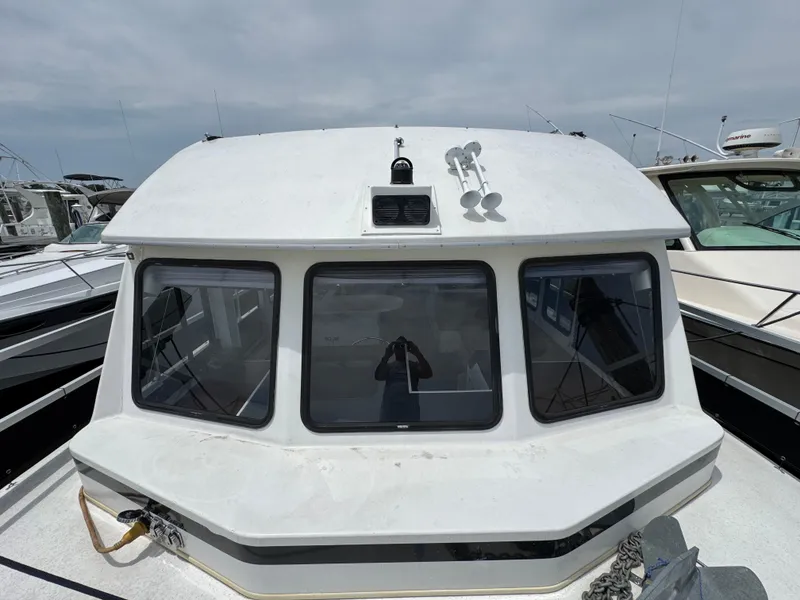 Slide: The Image of 1993 Gibson 37 Sport Series boat with white cabin and windows, docked at marina. - 4