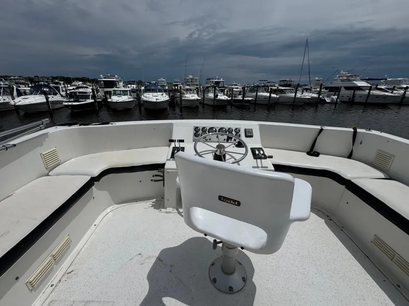 Slide: The Image of 1993 Gibson 37 Sport Series boat helm with marina view, featuring white seating and control panel. - 8