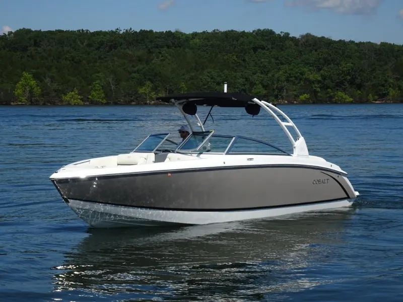 Slide: The Image of 2016 Cobalt R7 boat cruising on a serene lake with lush green shoreline. - 5