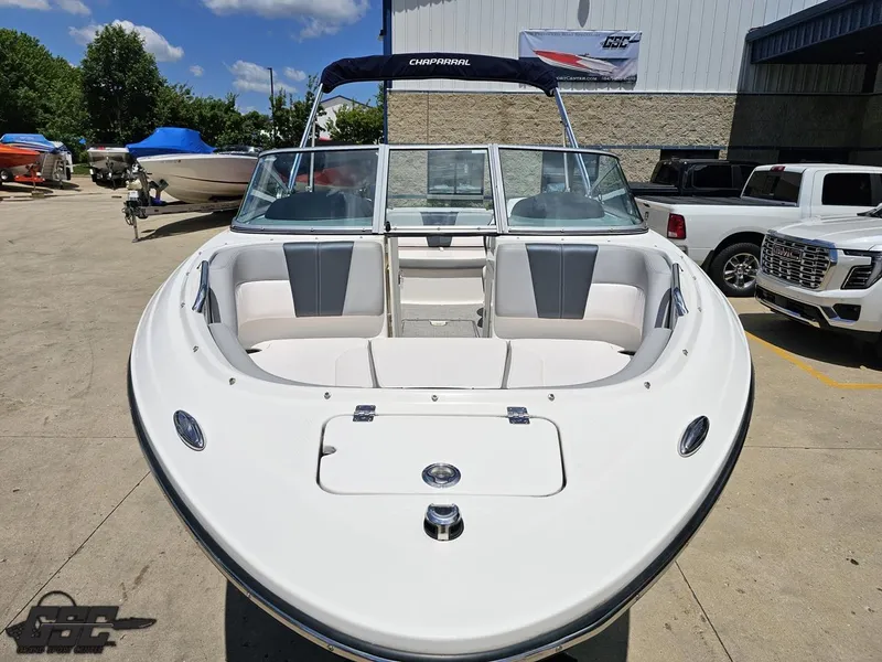 Slide: The Image of 2020 Chaparral 21 SSi boat with open bow seating, parked outdoors under clear skies. - 16