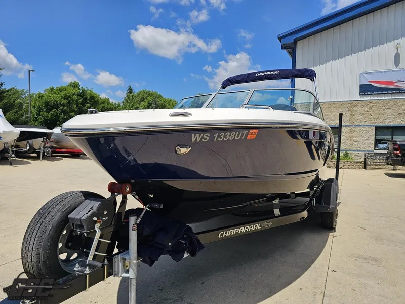 Slide: The Image of 2020 Chaparral 21 SSi boat on trailer, parked outdoors under a clear blue sky. - 18