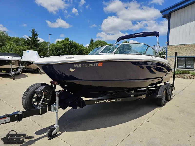 Slide: The Image of 2020 Chaparral 21 SSi boat on trailer, parked outdoors under a clear blue sky. - 19