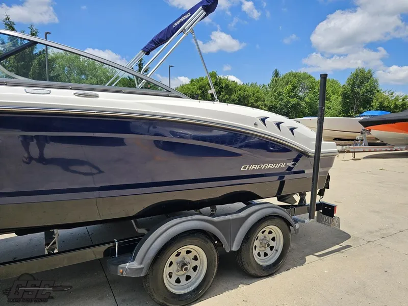Slide: The Image of 2020 Chaparral 21 SSi boat on trailer, parked outdoors under a clear blue sky. - 26