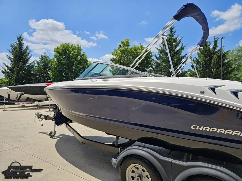 Slide: The Image of 2020 Chaparral 21 SSi boat on trailer, sunny day, blue sky, trees in background. - 28