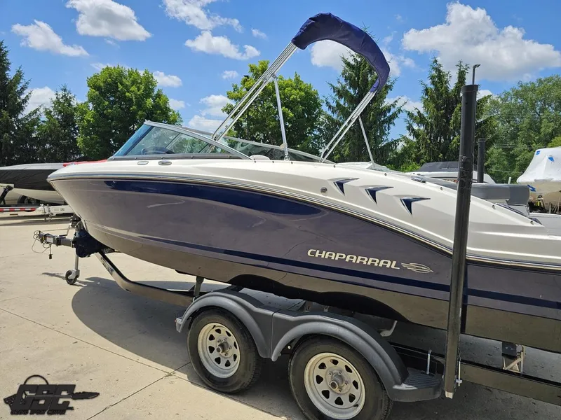 Slide: The Image of 2020 Chaparral 21 SSi boat on trailer, parked outdoors under a clear blue sky. - 30