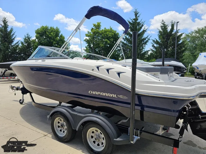 Slide: The Image of 2020 Chaparral 21 SSi boat on trailer, parked outdoors under a clear blue sky. - 31