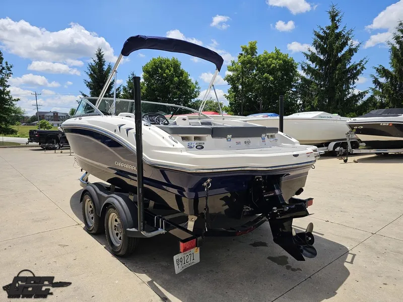 Slide: The Image of 2020 Chaparral 21 SSi boat on trailer, parked outdoors under a clear blue sky. - 33