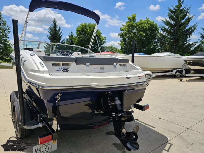 Slide: The Image of 2020 Chaparral 21 SSi boat on trailer, sunny day, parked with other boats. - 34