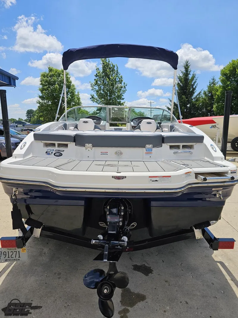 Slide: The Image of 2020 Chaparral 21 SSi boat with canopy, parked outdoors under a clear blue sky. - 37