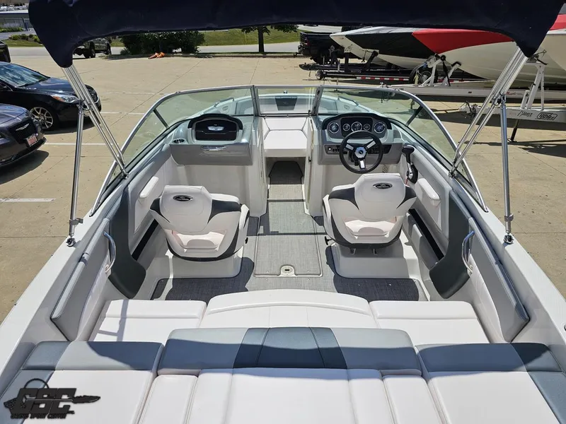 Slide: The Image of 2020 Chaparral 21 SSi boat interior with seating and steering wheel, parked outdoors. - 46