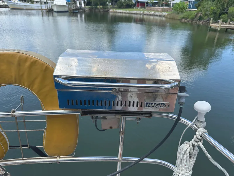 Slide: The Image of Stainless steel Magma grill on a 1984 Bristol 38.8 sailboat, docked by a serene lake. - 15
