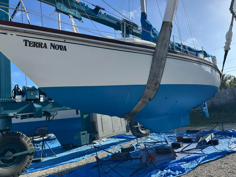 Slide: The Image of 1984 Bristol 38.8 sailboat "Terra Nova" in dry dock, blue hull, supported by a crane. - 4