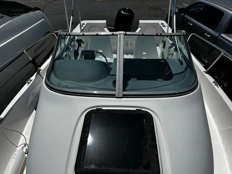 Slide: The Image of 1999 Bayliner Trophy 2002 boat with windshield and open cockpit, parked beside other vehicles. - 14