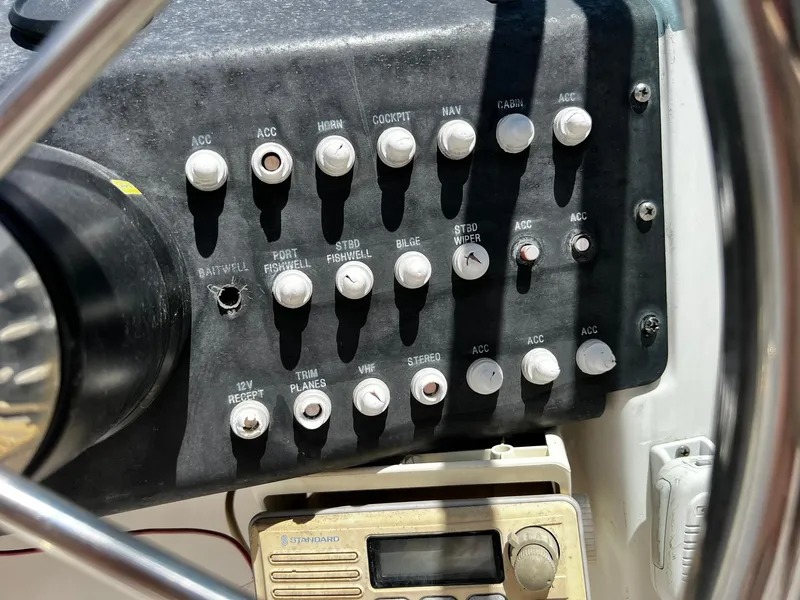 Slide: The Image of Control panel of a 1999 Bayliner Trophy boat with various switches and dials. - 21