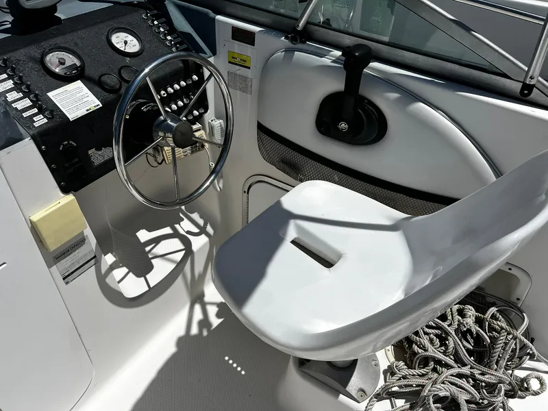Slide: The Image of 1999 Bayliner Trophy boat cockpit with steering wheel, controls, and seat. - 22