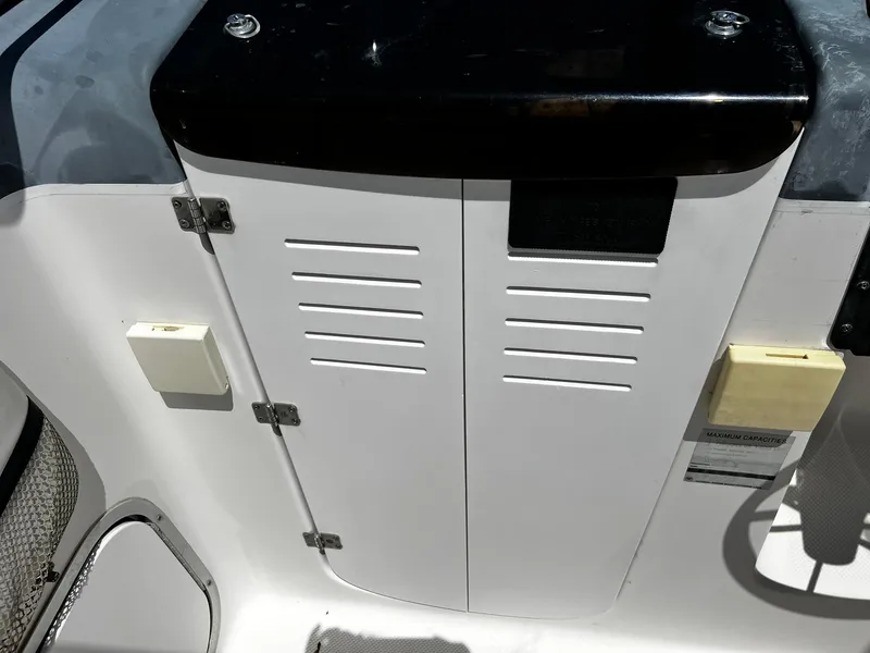 Slide: The Image of Bayliner 2002 Trophy boat interior, featuring storage compartment and control panel, 1999 model. - 24