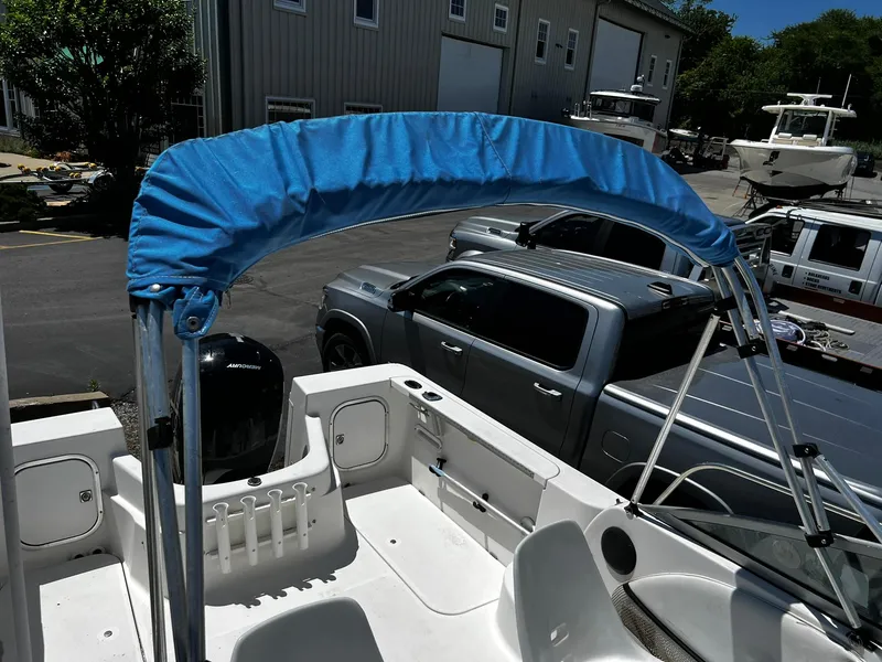 Slide: The Image of Bayliner 2002 Trophy boat, 1999 model, with blue canopy in a marina setting. - 26