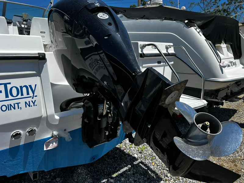 Slide: The Image of Bayliner 2002 Trophy boat, 1999 model, with outboard motor, parked on gravel. - 4