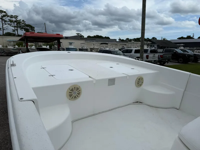 Slide: The Image of 2011 Carolina Skiff 218 DLV boat interior with storage compartments and speakers, parked outdoors. - 11