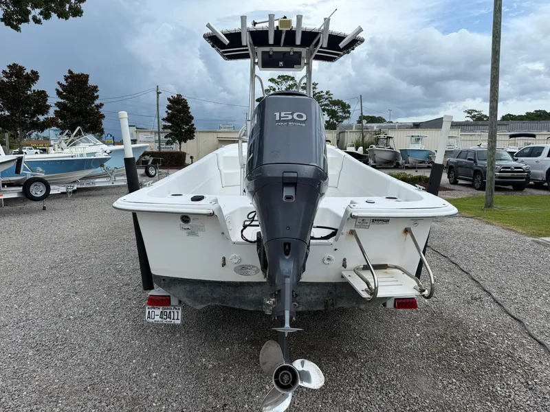 Slide: The Image of 2011 Carolina Skiff 218 DLV boat with 150 horsepower engine, parked outdoors. - 5