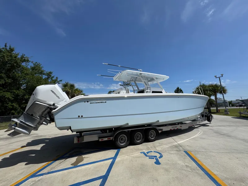 Slide: The Image of 2026 Invincible 38 Catamaran on trailer under clear blue sky. - 10
