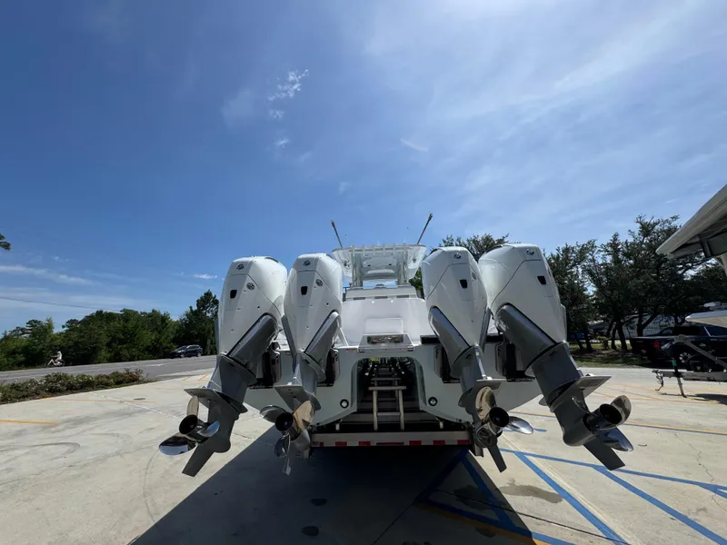 Slide: The Image of 2026 Invincible 38 Catamaran with four powerful outboard engines, parked outdoors. - 14