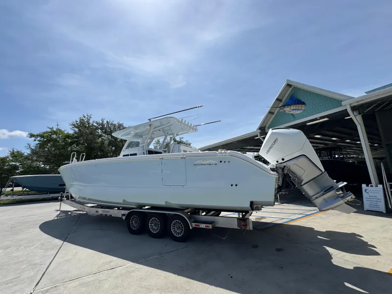 Slide: The Image of 2026 Invincible 38 Catamaran on trailer, parked outdoors under clear sky. - 17