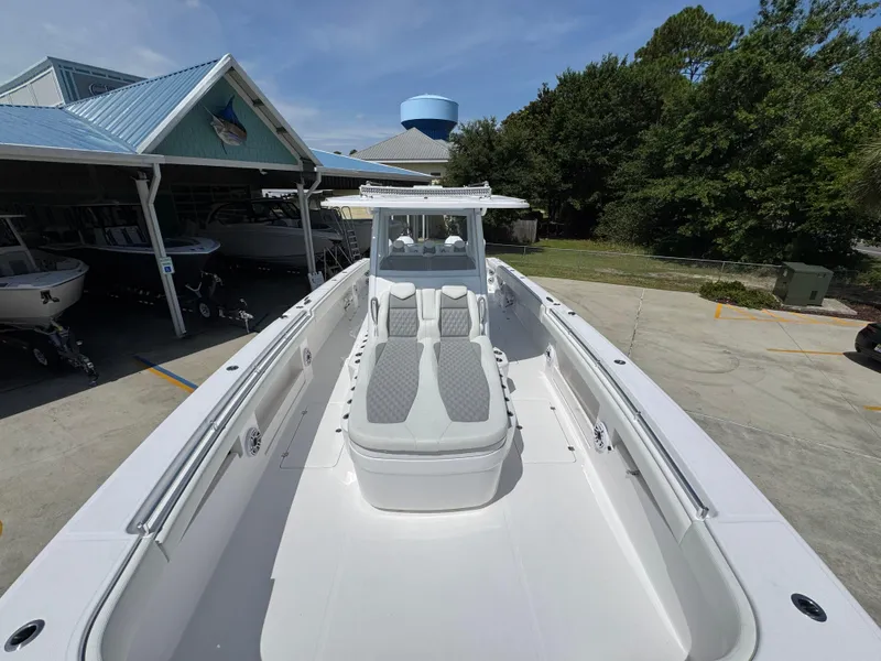 Slide: The Image of 2026 Invincible 38 Catamaran with sleek design, docked near a boat storage facility. - 19