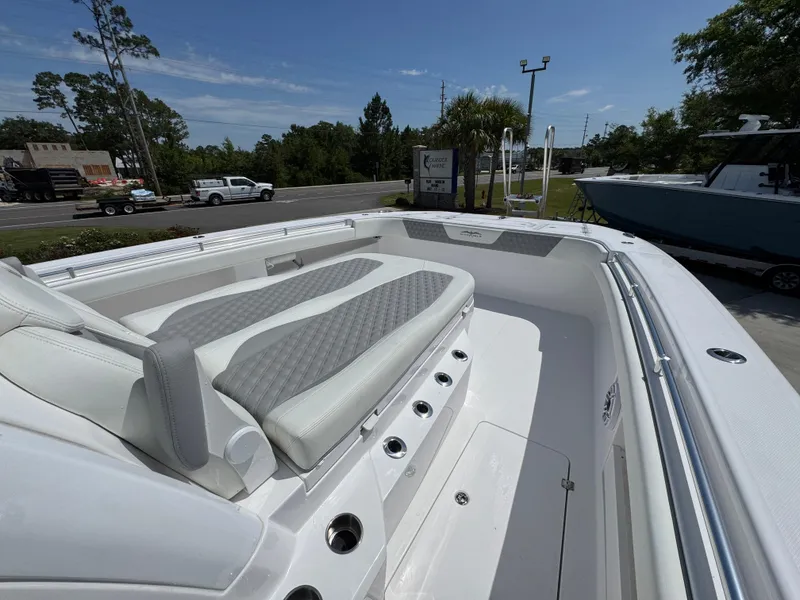 Slide: The Image of 2026 Invincible 38 Catamaran with sleek seating and modern design in a sunny outdoor setting. - 21