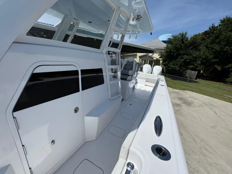 Slide: The Image of 2026 Invincible 38 Catamaran, sleek white deck, modern design, spacious seating, outdoor setting. - 24