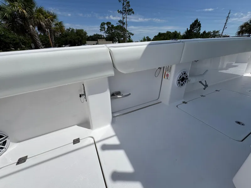 Slide: The Image of 2026 Invincible 38 Catamaran deck with storage compartments and speakers, under clear blue sky. - 34