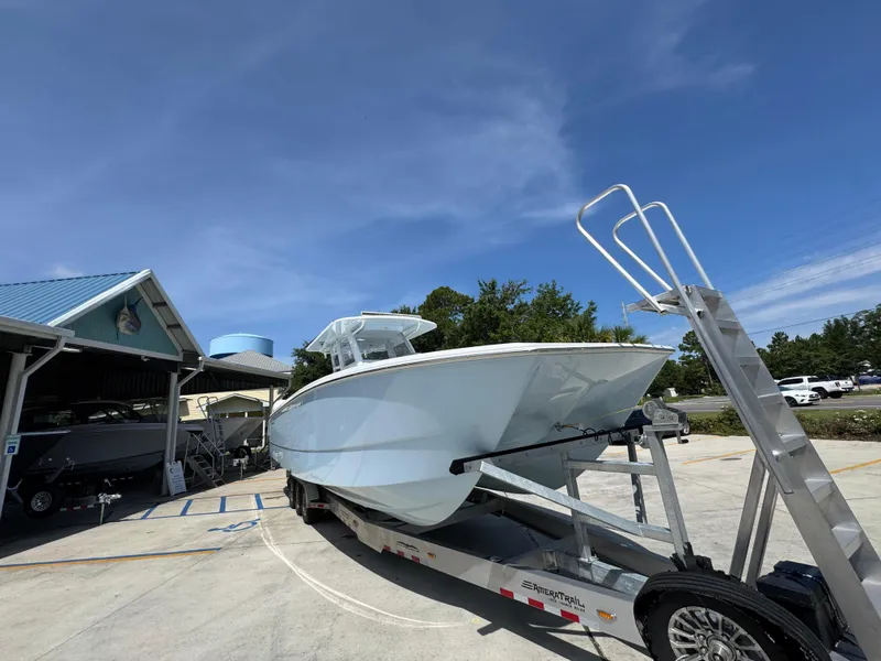Slide: The Image of 2026 Invincible 38 Catamaran on trailer, parked outdoors under clear blue sky. - 7