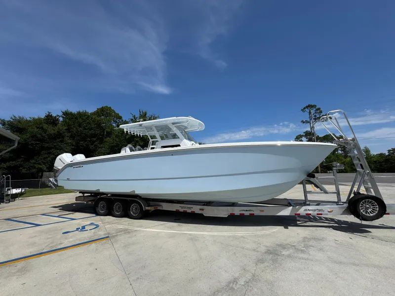 Slide: The Image of 2026 Invincible 38 Catamaran on trailer under clear blue sky. - 8