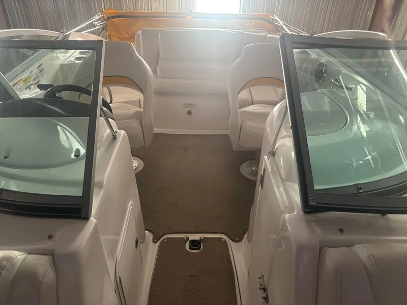 Slide: The Image of 2013 Hurricane SunDeck 2200 DC IO interior with seating and windshield, in storage. - 11