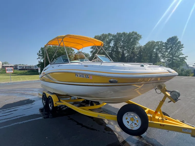 Slide: The Image of 2013 Hurricane SunDeck 2200 DC IO boat with yellow canopy on trailer, sunny day. - 5
