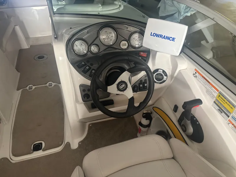 Slide: The Image of 2013 Hurricane SunDeck 2200 DC IO boat cockpit with steering wheel and Lowrance display. - 7