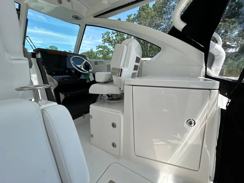 Slide: The Image of 2026 Pursuit DC 306 boat interior with sleek white seating and modern helm controls. - 16