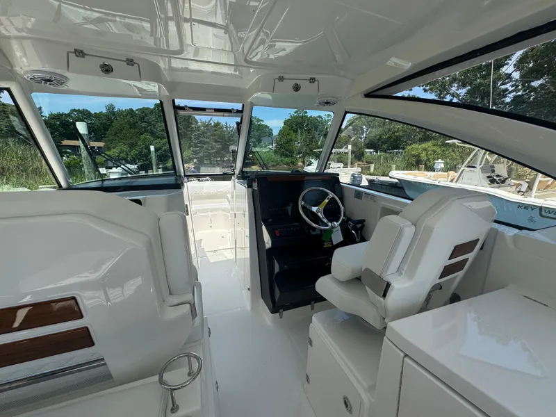 Slide: The Image of Interior of 2026 Pursuit DC 306 boat with modern helm and seating. - 18