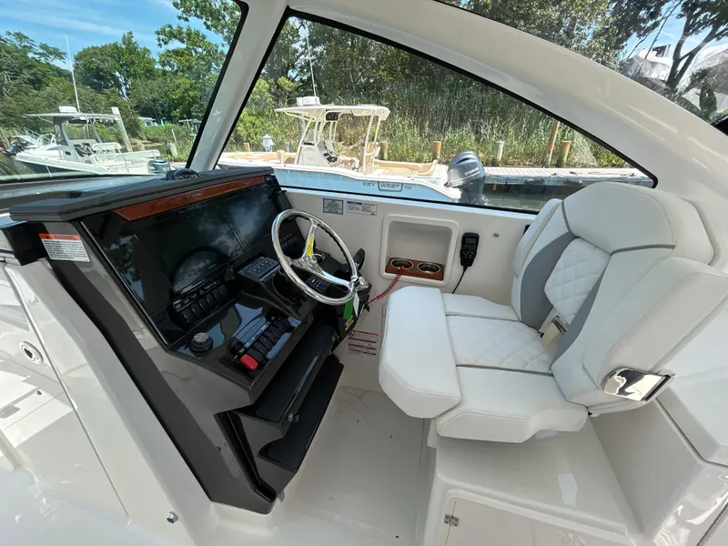 Slide: The Image of 2026 Pursuit DC 306 boat cockpit with modern steering and comfortable seating. - 19