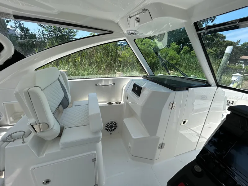 Slide: The Image of 2026 Pursuit DC 306 boat interior with white seating and modern dashboard design. - 21