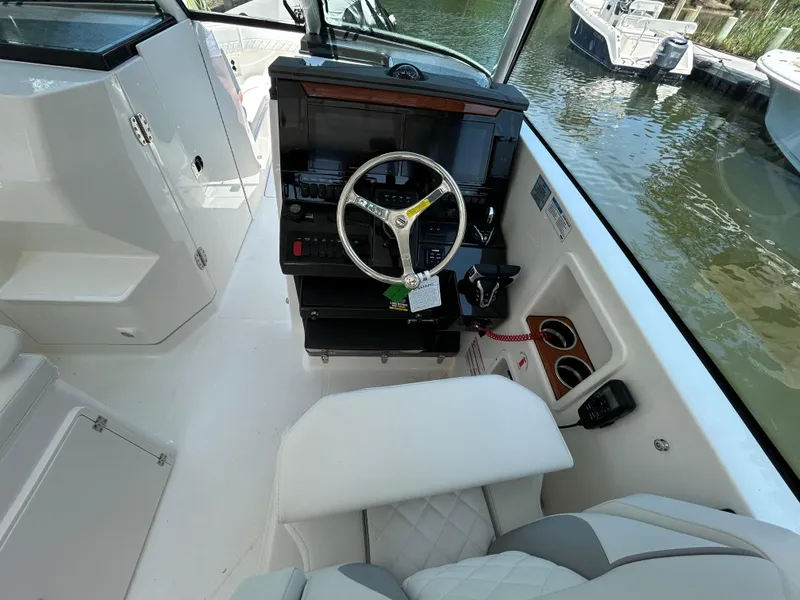 Slide: The Image of Helm of 2026 Pursuit DC 306 boat with steering wheel and control panel. - 22