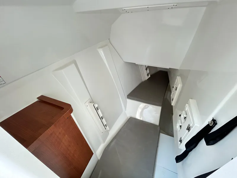 Slide: The Image of 2026 Pursuit DC 306 cabin interior with seating and wooden storage. - 31