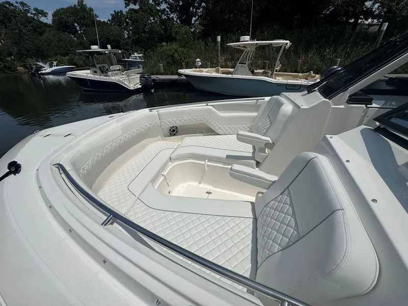 Slide: The Image of Luxurious 2026 Pursuit DC 306 boat interior with white quilted seating and sleek design. - 33